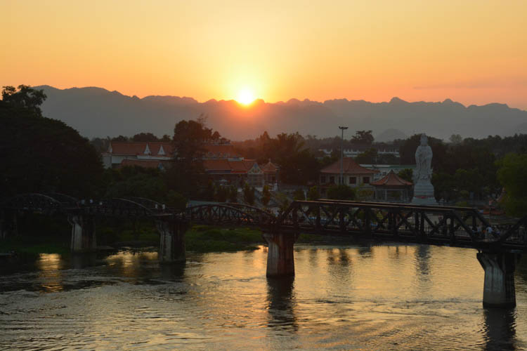 Západ slunce za horami a mostem přes řeku Kwai, Kanchanaburi, Thajsko