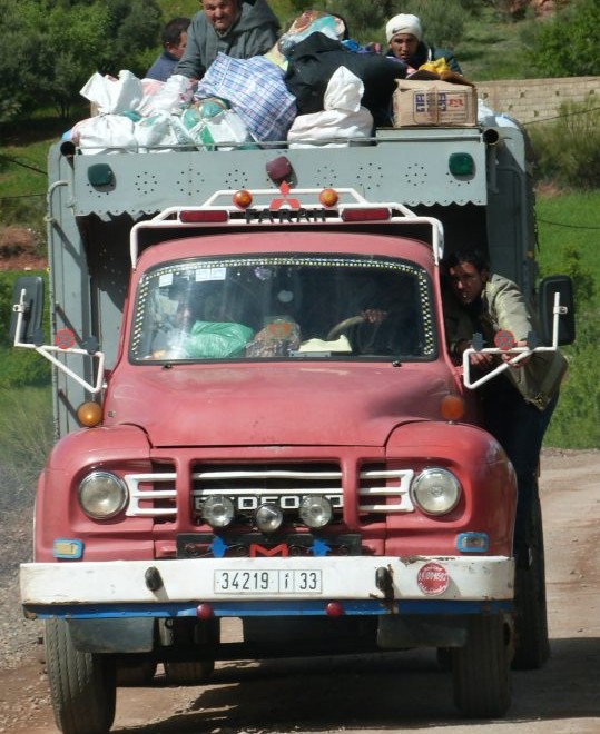 Berberští muži na korbě nákladního automobilu.