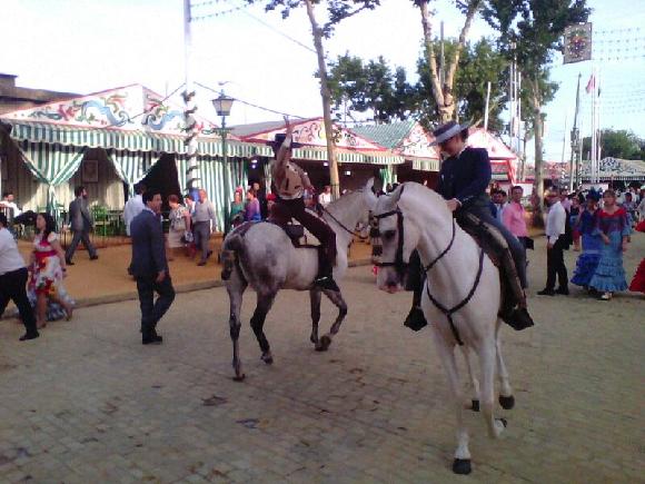 Koně s profesionálními jezdkyněmi tančící Sevillanu během Feria de Abril