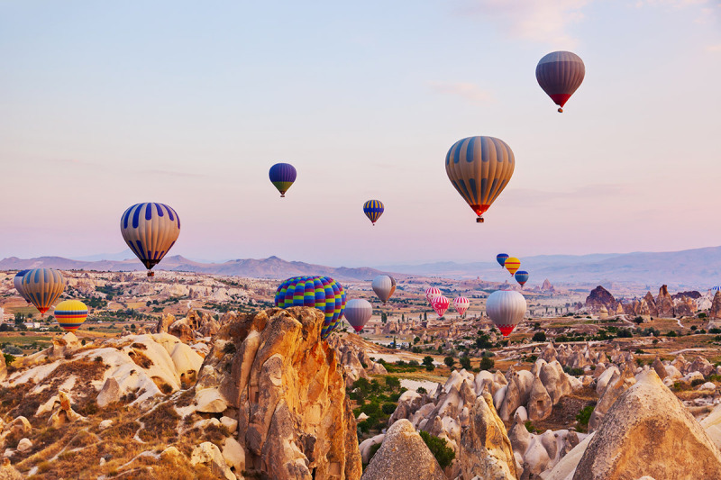 Turecko - horkovzdušné balony vznášející se nad obzorem Kappadokie