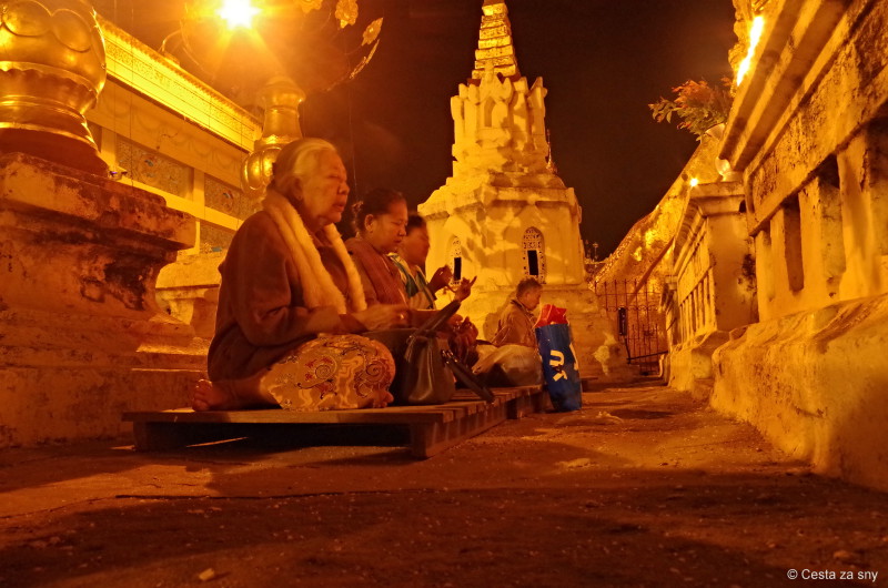 Buddhistická slavnost a místní meditující lidé.