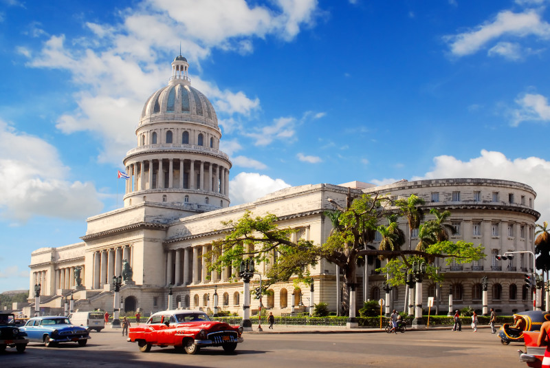 Historické americké auto před budovou Capitolio v Havaně na Kubě na náměstě Plaza de la Catedral.