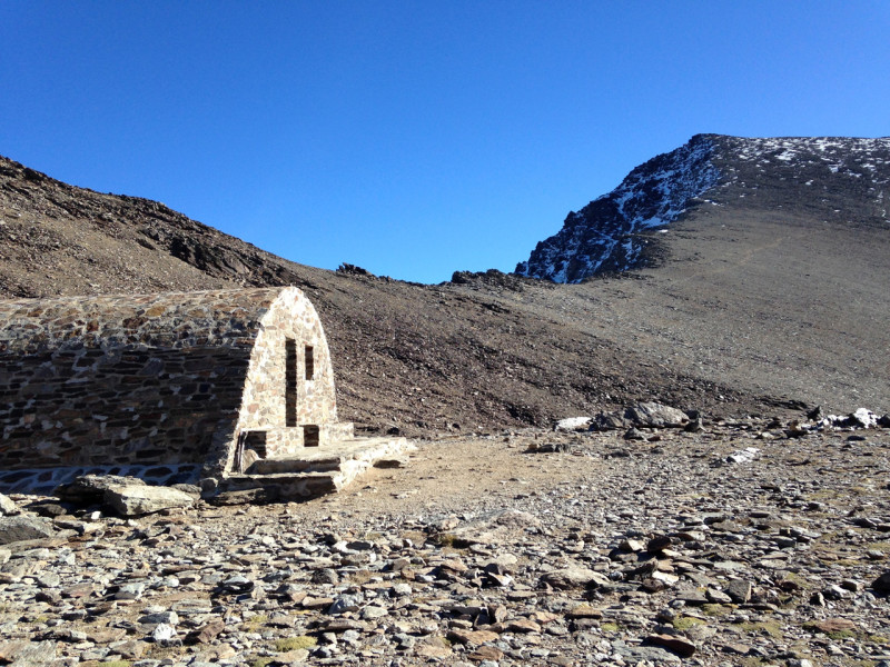 Chatka Refugio Vivac de la Caldera, kde jsme před výstupem nechali bagáž. V dáli je vidět Mulhacén.