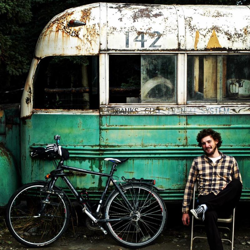 I, Cycleast – Matěj Balga před proslulým autobusem z filmu Útěk do divočiny, ve kterém si v divoké krajině Aljašky žil Chris McCandless svůj vysněný život dobrodruha.