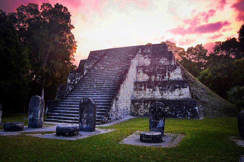 Západ slunce za pyramidou v dávném městě Mayů Tikal, Guatemala.